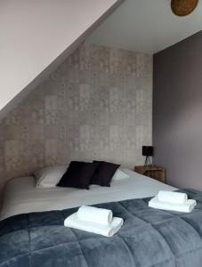 a bedroom with a bed with two towels on it at Au Gîte Savignéen in Savigné-lʼÉvêque