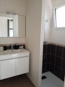 Un baño con un lavabo blanco y un espejo. en Armor, en Bonne Nouvelle 10 fotos más