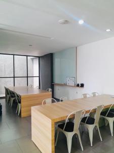 a conference room with a large wooden table and chairs at Behomy Maxley Lippo Karawaci in Tangerang
