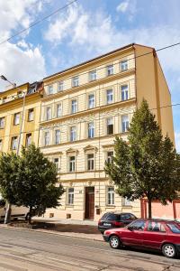 ein Gebäude mit zwei davor geparkt in der Unterkunft Kasablanka apartments in Prag
