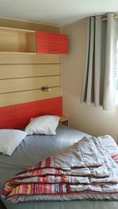 een slaapkamer met een bed met een rood hoofdeinde bij Euro Mobil B16 in Boofzheim +41 foto's