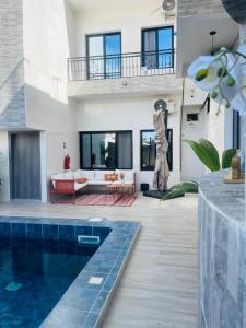 een woonkamer met een zwembad en een huis bij VillAïda Appartement 001 in Darou Rhamane