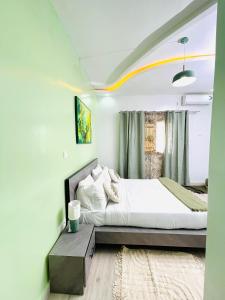 een slaapkamer met een groot bed en een raam bij VillAïda Appartement 001 in Darou Rhamane +37 foto's