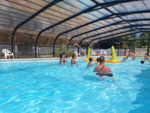 un groupe de personnes dans une piscine dans l'établissement Camping 4 étoiles - Piscine - eec0di, à Fouesnant