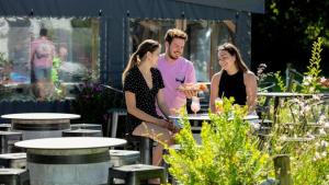 un groupe de trois personnes debout dans un jardin dans l'établissement Camping 4 étoiles - Piscine - eec0di, à Fouesnant