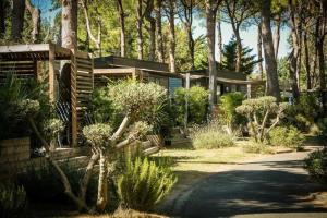 une maison au milieu d'un jardin arboré dans l'établissement Camping 4 étoiles - Piscine - ccaaeag, à Canet