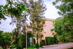 a building on the side of a street with trees at Hill View Hotel Kiyovu in Kigali