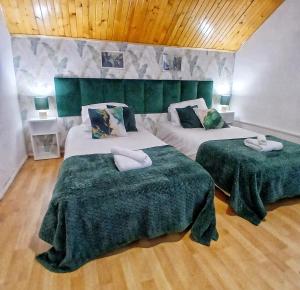 - une chambre avec 2 lits avec des draps verts et blancs dans l'établissement KRK stop, à Cholerzyn 6 autres photos