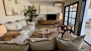 uma sala de estar com um sofá e uma mesa em Villa premium, tribu friendly, vaste patio & piscine em Mauguio