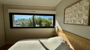 um quarto com uma cama e uma janela grande em Villa premium, tribu friendly, vaste patio & piscine em Mauguio mais 101 fotografias