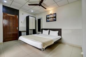 Schlafzimmer mit einem großen weißen Bett und einer Decke in der Unterkunft Hotel Sukoon & Banquet Hall Near Bhopal Railway Station in Bhopal