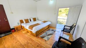 une chambre avec un lit, une fenêtre et une chaise dans l'établissement Accomoon River Side Cottages, à Dirang Dzong