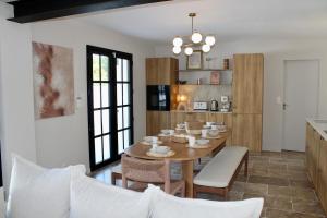 uma sala de jantar e cozinha com mesa e cadeiras em Villa premium, tribu friendly, vaste patio & piscine em Mauguio