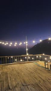 une promenade en bois illuminée sur une jetée la nuit dans l'établissement Chà Homestay, à Bắc Yên