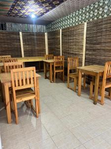 une salle à manger avec des tables et des chaises en bois dans l'établissement Residencial Bom Desc & Conforto, à Santo António