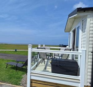 a white deck with a table and chairs on a house at Our Sea View - Heysham in Heysham