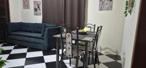 ein Tisch und Stühle in einem Wohnzimmer mit einer Couch in der Unterkunft Casa Pouso Aconchego Para Ti - pertinho de Trindade com conforto e churrasqueira in Paraty