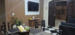 ein Wohnzimmer mit einer Couch, einem Tisch und einem Fernseher in der Unterkunft Casa Pouso Aconchego Para Ti - pertinho de Trindade com conforto e churrasqueira in Paraty