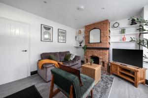 a living room with a couch and a fireplace at Modern Bletchley home with stylish decor in Bletchley +18 photos