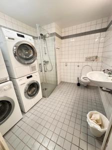 une salle de bains avec lave-linge et lavabo dans l'établissement Guesthouse good location, à Oslo