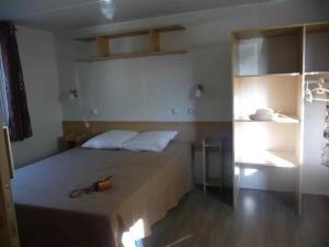 a bedroom with a bed with a pair of glasses on it at ZEcamping 4 étoiles chiens acceptés bien-être piscine couverte in Azur