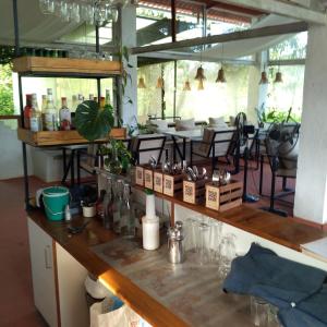 un mostrador en una habitación con mesas y sillas en Rustic Palms, en Thāl