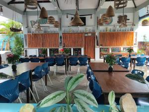 a dining room with tables and chairs and plants at Ferellee Beach Front Inn in San Vicente
