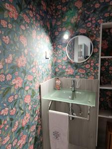 a bathroom with a sink and floral wallpaper at Les Casetes in La Senia