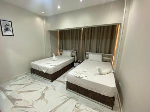 Una habitación de hotel con dos camas y un espejo. en Golden Memphis Cairo Hotel, en El Cairo