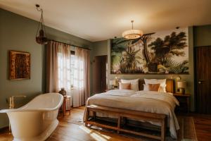 1 Schlafzimmer mit einer Badewanne, einem Bett und einer Badewanne in der Unterkunft Vabali Spa Hamburg Hotel in Glinde + 28 Fotos