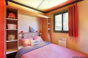 een kleine slaapkamer met een bed en een raam bij Chalet 3 étoiles - Piscine - eeigai in Darbres +59 foto's