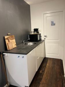 una cocina con fregadero y microondas en Studio 3, en Axel