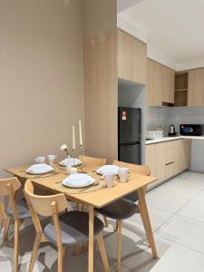 a kitchen with a wooden table with chairs and a dining room at Southplace Tropicana Metropark by HostInn in Subang Jaya