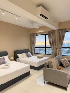 a hotel room with two beds and a couch at Southplace Tropicana Metropark by HostInn in Subang Jaya