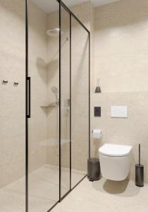 ein Badezimmer mit Glasdusche und WC in der Unterkunft Hotel Siscia in Sisak + 21 Fotos