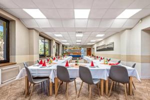 a row of tables in a room with red napkins at Penzión VODÁR in Donovaly