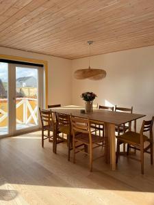 a dining room with a wooden table and chairs at Gult Strandhus Med Udsigt Over Løkken in Løkken