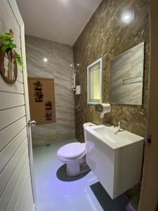 ein Badezimmer mit einer weißen Toilette und einem Waschbecken in der Unterkunft Grand Bangsaen Hotel in Bangsaen