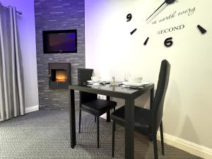a dining room with a table and chairs and a clock at Maggie's Lodge in Leeds +19 photos
