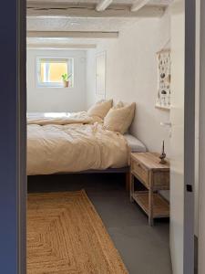 a bedroom with a bed with a window and a table at Gult Strandhus Med Udsigt Over Løkken in Løkken +31 photos