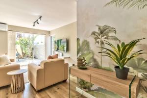 布鲁堡史特兰Modern Duplex Fully Air-Conditioned near Beach的客厅配有椅子和桌子,种植了植物