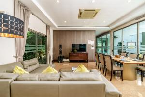 a living room with a couch and a dining room at Villa Navin Beach Residence in Jomtien Beach