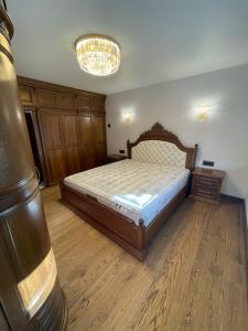 ein Schlafzimmer mit einem Bett und einem Kronleuchter in der Unterkunft Luxury Apartment Downtown Blagoevgrad in Blagoewgrad