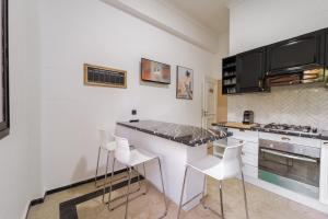eine Küche mit einer Theke und einigen weißen Stühlen in der Unterkunft Charming Flat with AC Fast Wifi Secure Residence in Oulad Akkou