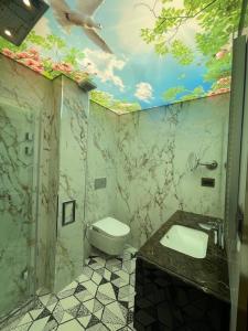 ein Badezimmer mit Toilette und einem Fischgemälde an der Decke in der Unterkunft Luxury Apartment Downtown Blagoevgrad in Blagoewgrad