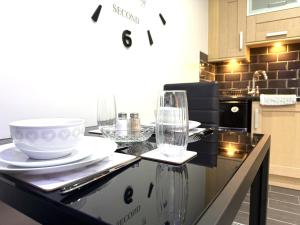 a kitchen with glasses and plates on a counter at Maggie's Lodge in Leeds