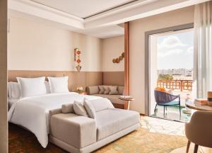 Un dormitorio con una cama, una silla y una ventana en Four Seasons Hotel Rabat at Kasr Al Bahr, en Rabat