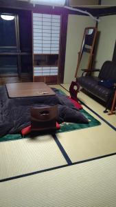 a bedroom with a bed and a laptop on the floor at Minshuku Hiroshimaya in Kumamoto