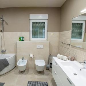 een badkamer met toilet, bad en wastafel bij Apartamento Italia in Međugorje