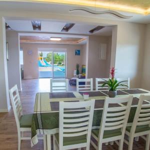 een eetkamer met een tafel en witte stoelen bij Apartamento Italia in Međugorje